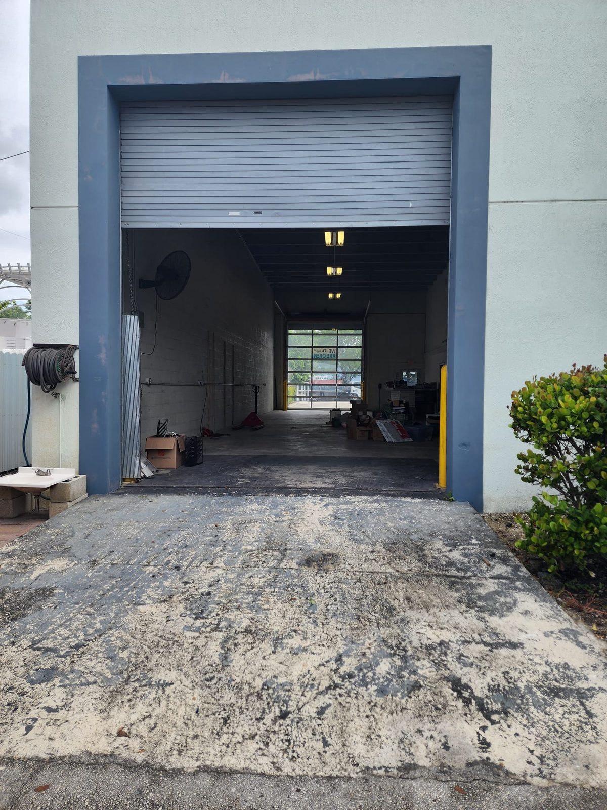 Grade-level drive-in door open to the gated yard